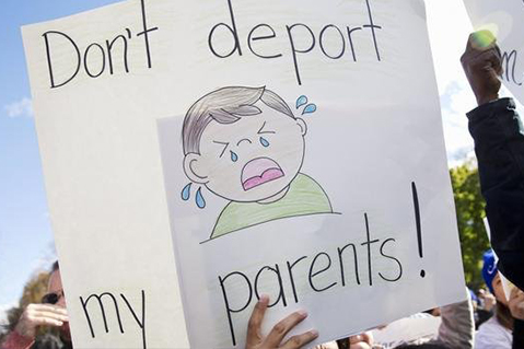 Una manifestante en contra de las deportaciones sostiene una pancarta frente a la Casa Blanca. 