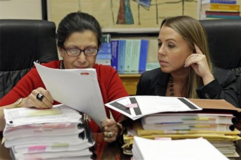Abogadas  en Miami revisan documentos de clientes con orden de deportaciones. Foto Alan Diaz / AP