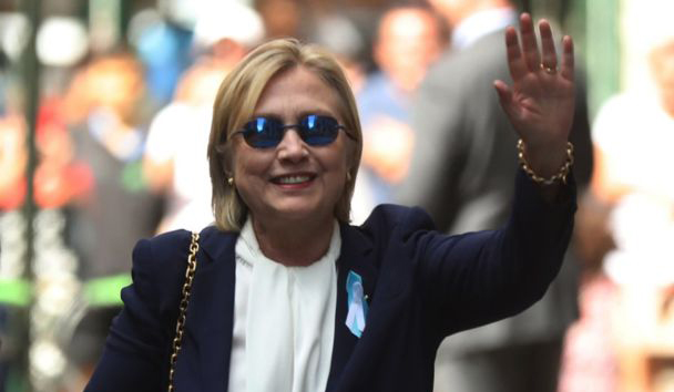 Clinton saluda a los fotógrafos al salir de la casa de su hija en Nueva York.