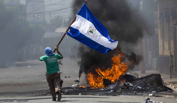 Un joven corre con una bandera en Masaya durante los recientes disturbios en contra de Daniel Ortega y su esposa. EFE