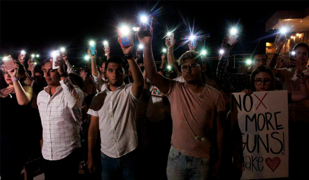 Varias personas sostienen sus teléfonos con el flash encendido en señal de solidaridad con las víctimas de la matanza de El Paso (EE UU), este sábado en Ciudad Juárez (México). HERIKA MARTINEZ AFP